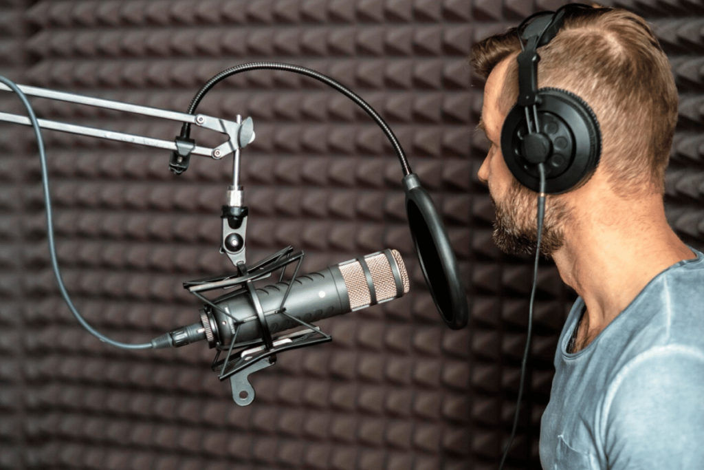 A person wearing headphones in front of a microphone.