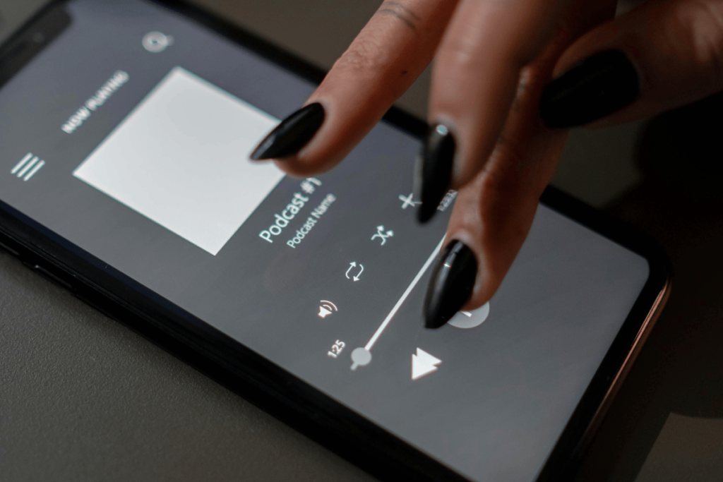 Close-up of a hand adjusting the playback on a podcast app on a smartphone.