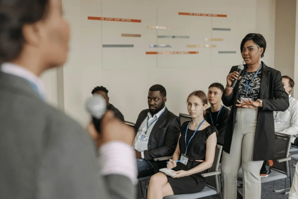 Professional woman participating in a Q&A session at a meeting.