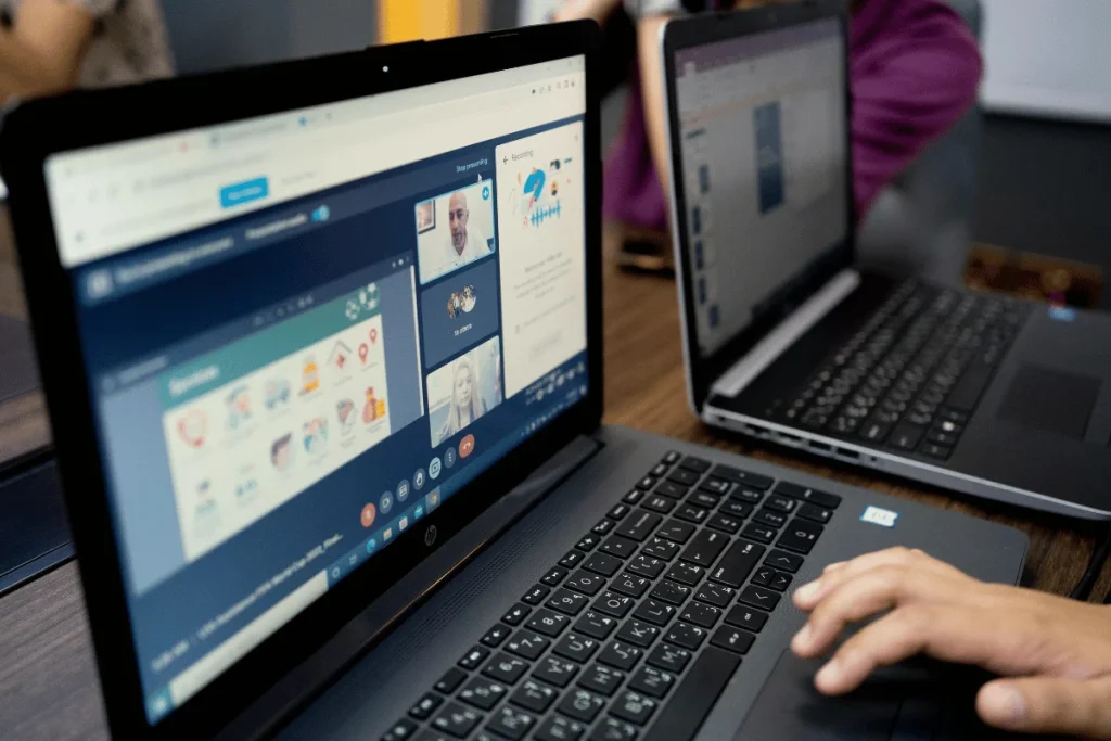 Remote collaboration setup with multiple screens showcasing video and slides.