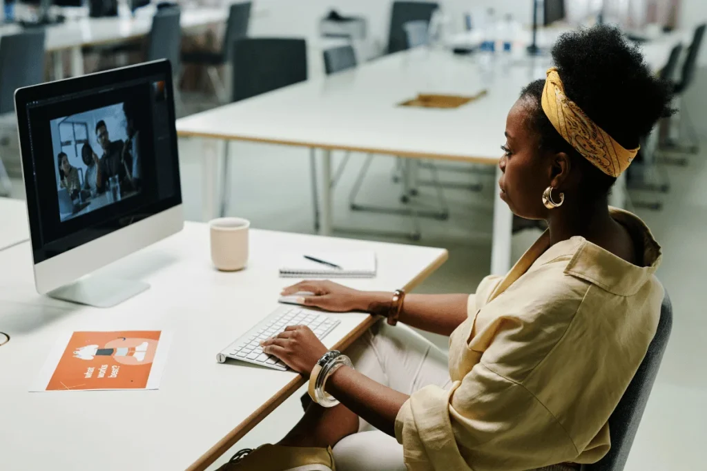Office employee editing an image on a computer while seated at a desk.