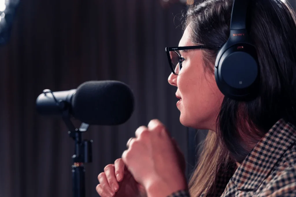A professional woman recording with a professional microphone, podcasting or singing at home.