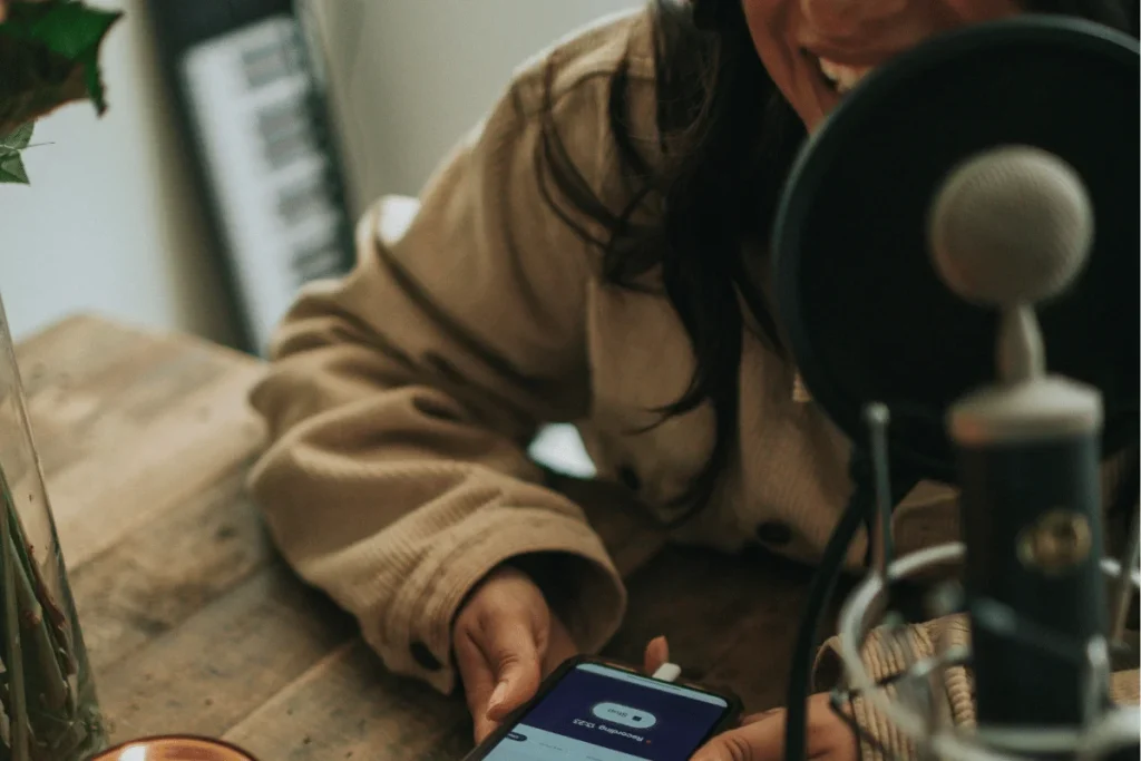 Person with phone and microphone laughing.