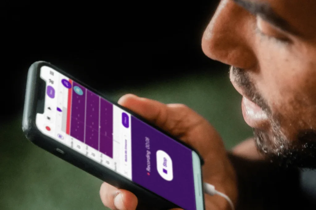 Man using smartphone with music app.
