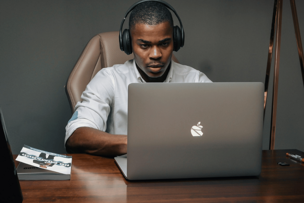 Concentrated man in headphones works on a laptop in an office setting.