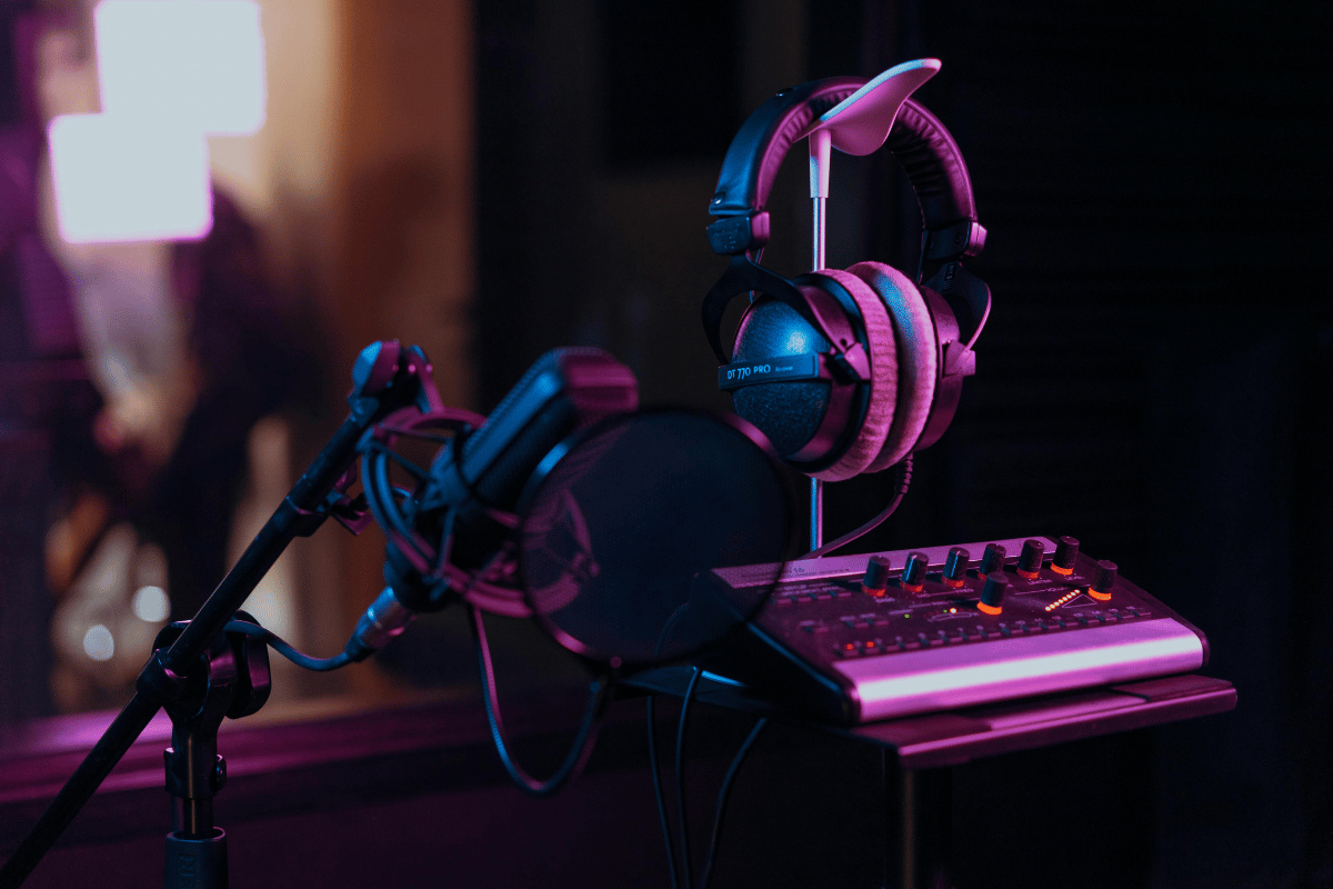 Professional recording studio microphone and headphones with neon lighting.