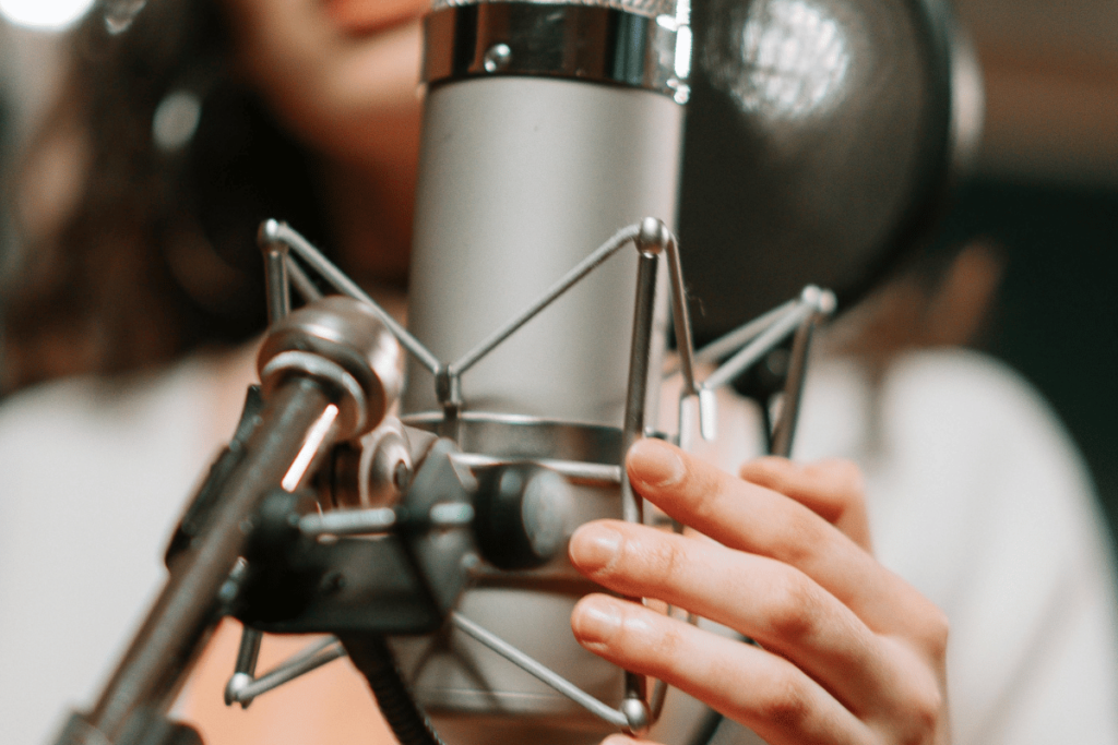 Hands setting up a condenser microphone in studio.