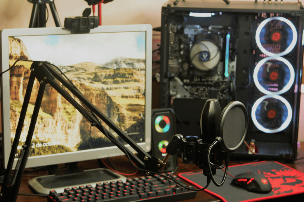 A detailed gaming setup with illuminated PC tower and dual monitors on a desk.