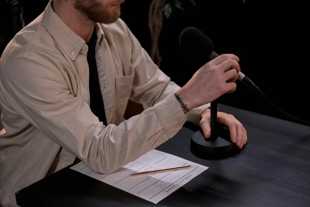 Man holding a microphone, preparing for a podcast recording.