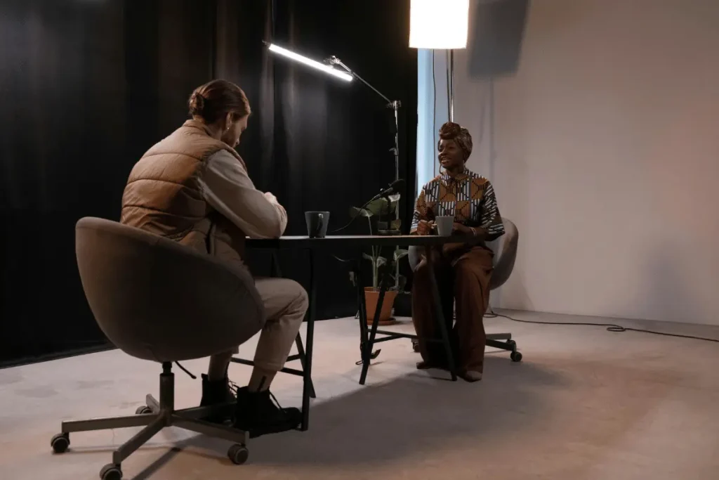 Two people having a conversation at a table in a dimly lit room.