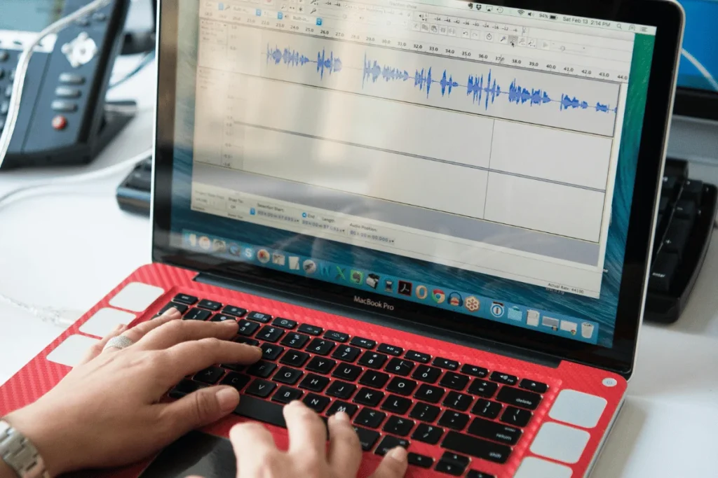 Audio editing on MacBook Pro with waveform displayed.