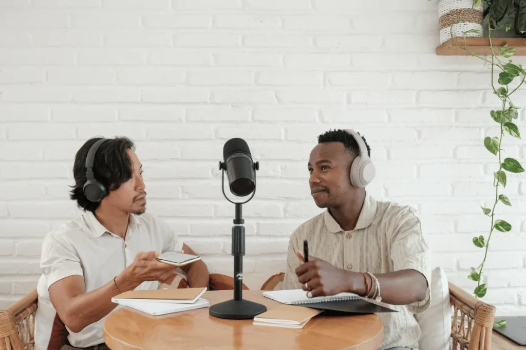 Two men wearing headphones recording a podcast together.