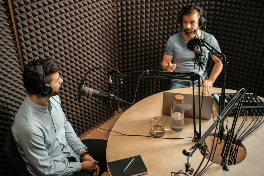Two men recording a podcast in a soundproof studio.