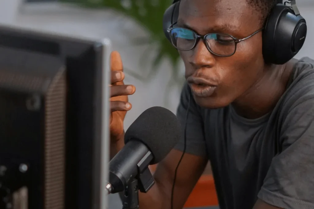 Engrossed man recording podcast with professional mic and headset.