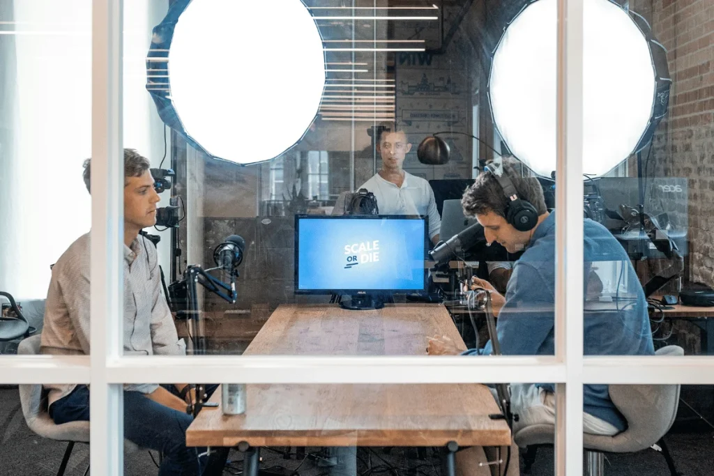 Podcast hosts and guests recording an episode in a well-lit studio.