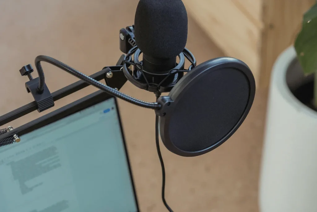 Close-up of a condenser microphone with a screen filter in a studio.