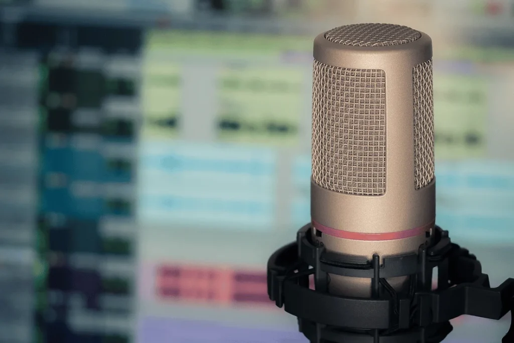 Professional studio microphone set against a blurred editing screen background.