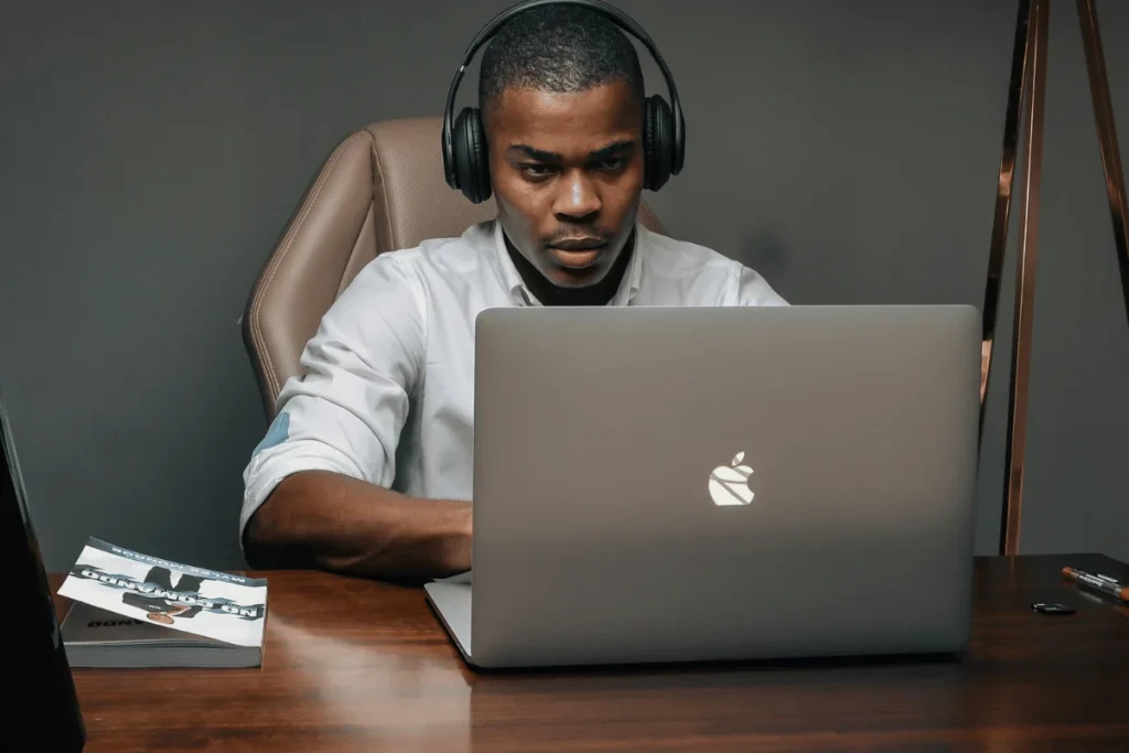 Professional engaging with his computer for a remote meeting or podcast.