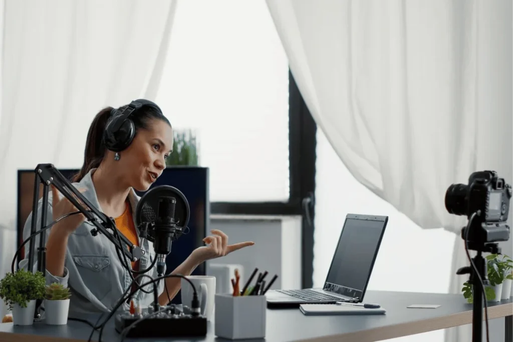 Woman with headphones and microphone recording a podcast.