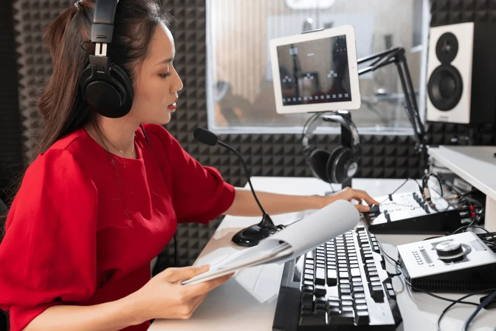Woman recording podcast in soundproof studio.