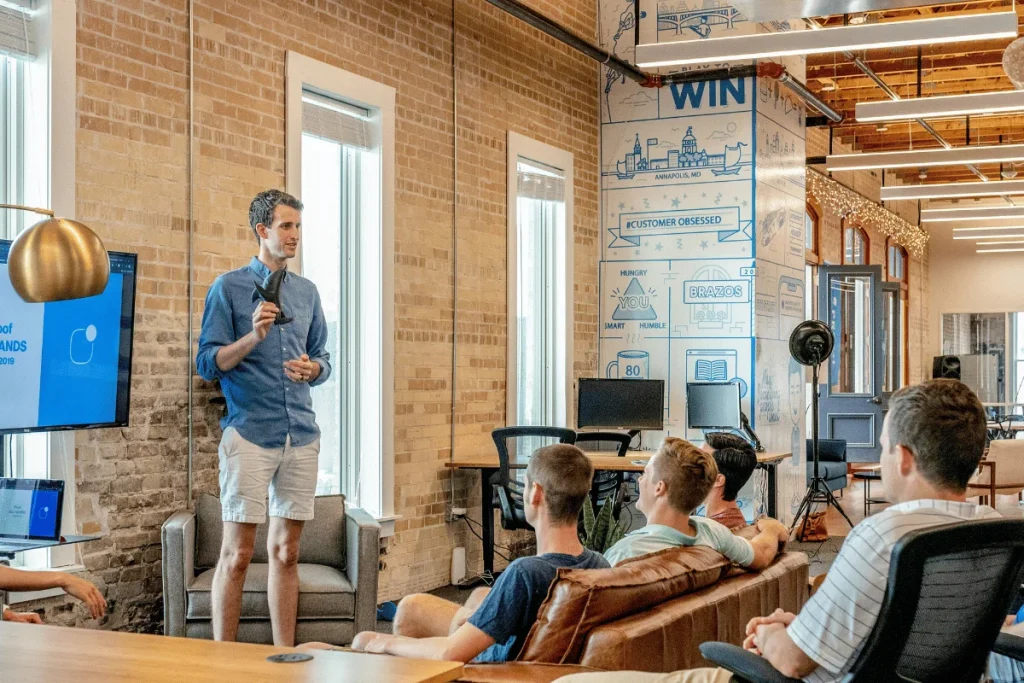 A team leader giving a presentation in a modern office setting.