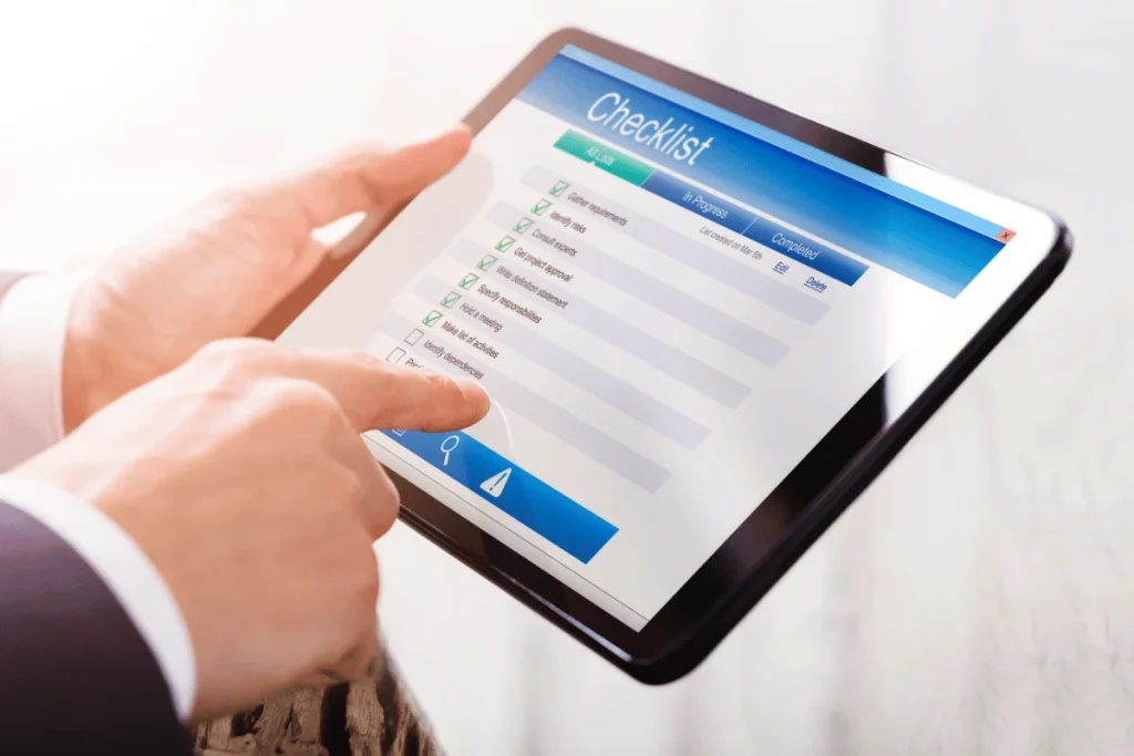 Person using a tablet displaying a checklist with various items, some checked off.