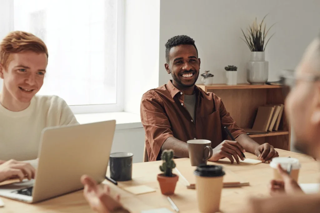 Diverse group of colleagues having a lively discussion during a meeting in a bright office.