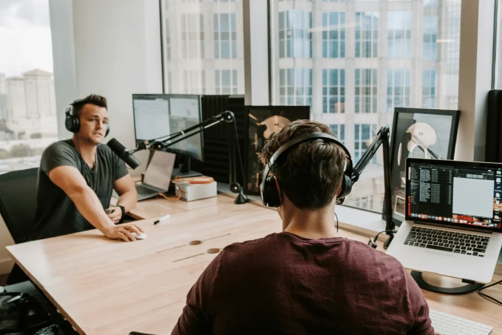 Professional podcast setup with microphones and laptops.