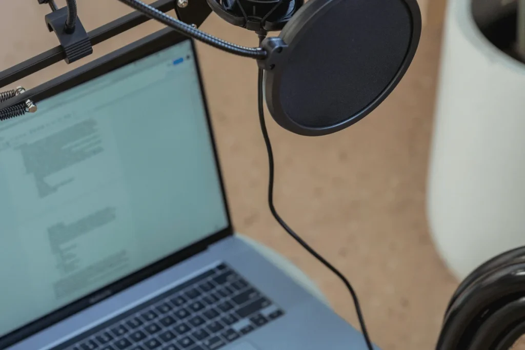 Podcast recording station with mic and laptop visible.
