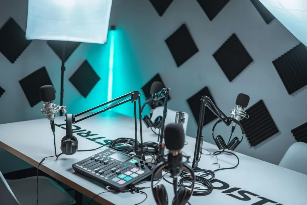 A professional podcast studio setup with microphones, headphones, and audio equipment on a table.