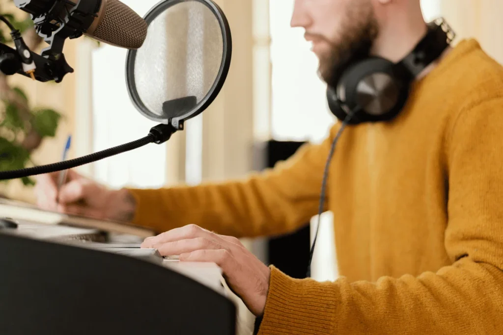 Man recording audio with microphone and pop filter.