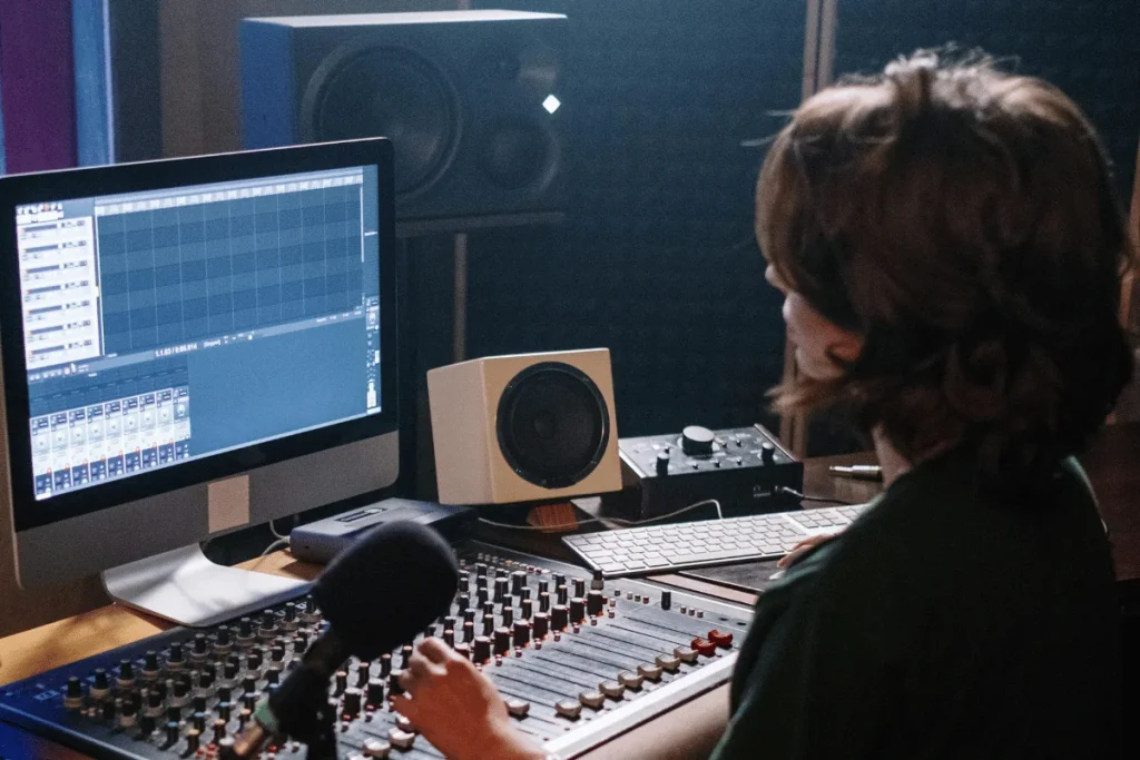 Sound engineer editing audio on iMac in studio.