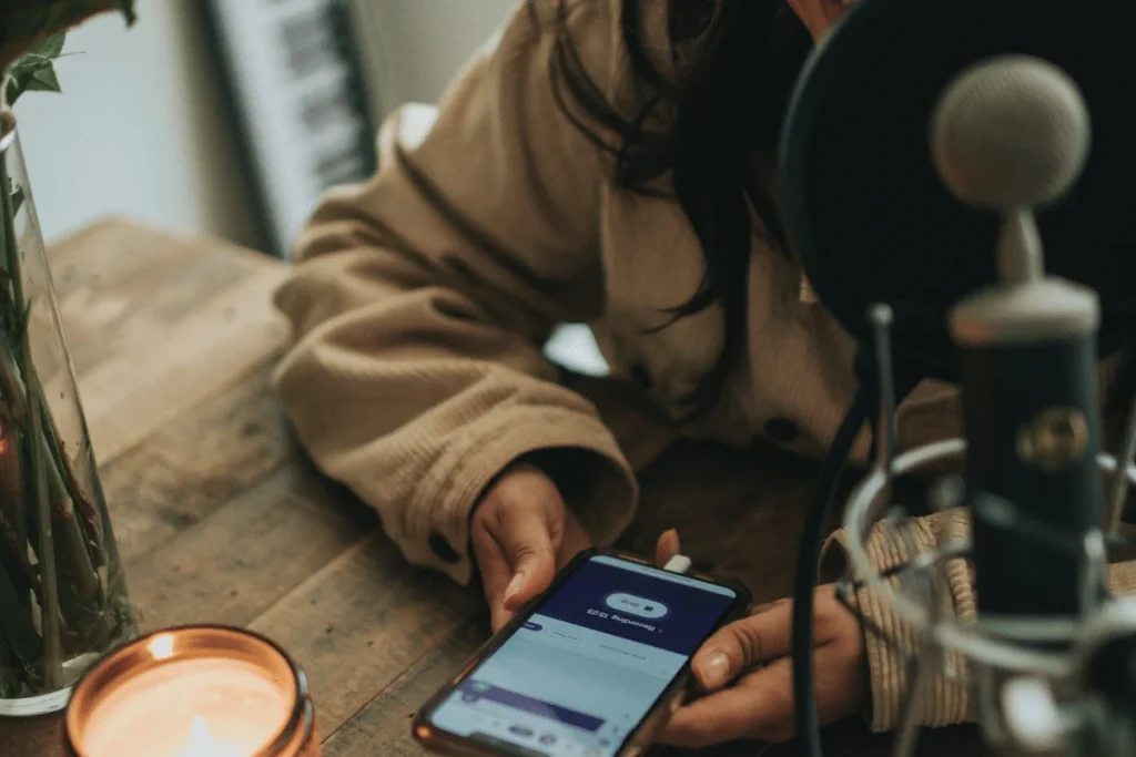 User interacting with podcast app on mobile by the mic.