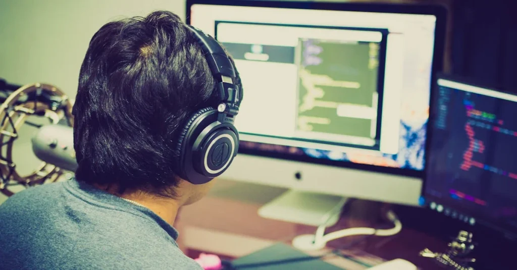 Podcaster wearing headphones at desk with multiple monitors displaying remote podcast recording software and audio levels.
