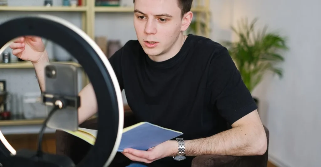 Content creator recording an online course with a smartphone and ring light for e-learning and video marketing.